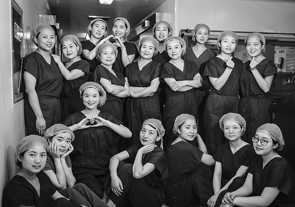 《团队》才俊 摄   平日里都是鲜花般的姑娘们，上班就换上了洗手衣，褪去了靓丽的衣服，都是一个模样，每日战斗在繁忙的临床一线。不想拍成一排排的传统形式，就让她们自己自然的摆在一起，拍成黑白是为了凸显这种仪式感，吸引读者专注于光影和面孔，注意力而不为鲜艳的手术衣所干扰。.jpg