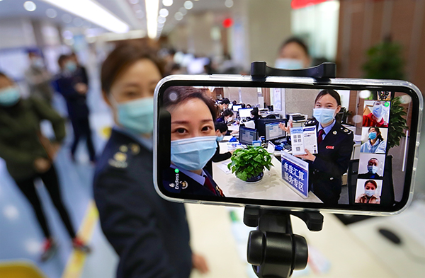 《直播培训纳税人》 李鑫 摄   疫情期间，西安市航天税务工作人员，通过手机直播平台为纳税人现场答疑解惑个税申报相关事项。.jpg